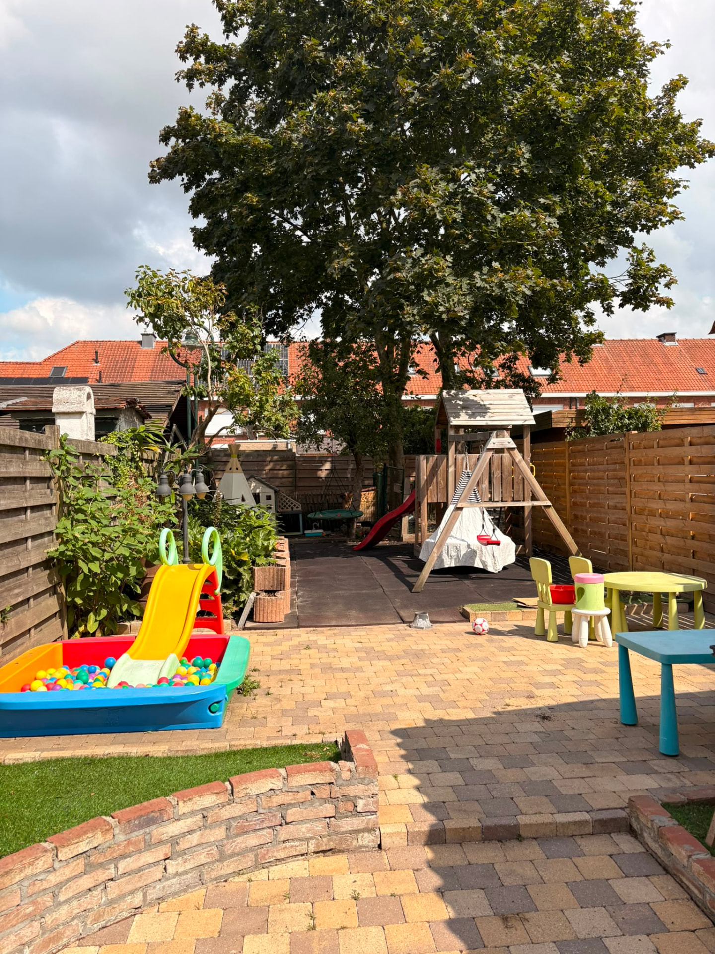 Tuin met speeltuin, glijbaan en ballenbad